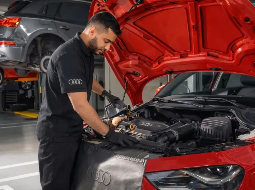 Mecânico especialista Audi realizando manutenção no motor de Audi vermelho com capô aberto na oficina Premium Car em Porto Alegre