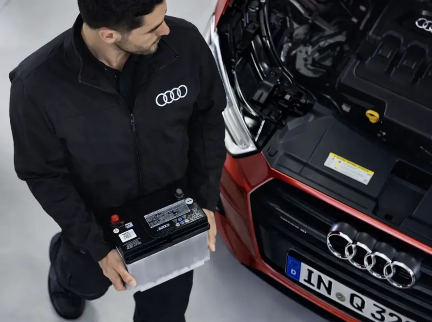 Mecânico especialista Audi realizando troca de bateria em Audi Q3 vermelho na oficina Premium Car em Porto Alegre
