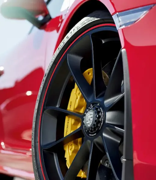 Porsche vermelho em alta velocidade com detalhe da roda esportiva e pinça de freio amarela, atendido pela oficina especializada Premium Car em Porto Alegre