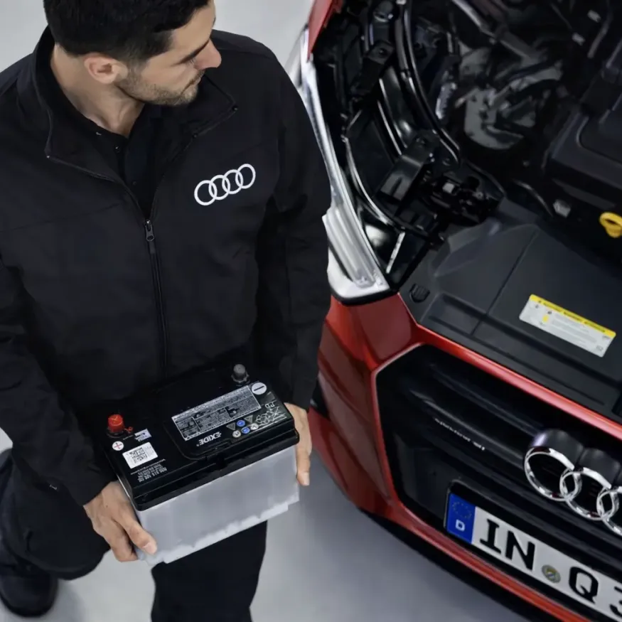 Mecânico especialista Audi realizando troca de bateria em Audi Q3 vermelho na oficina Premium Car em Porto Alegre